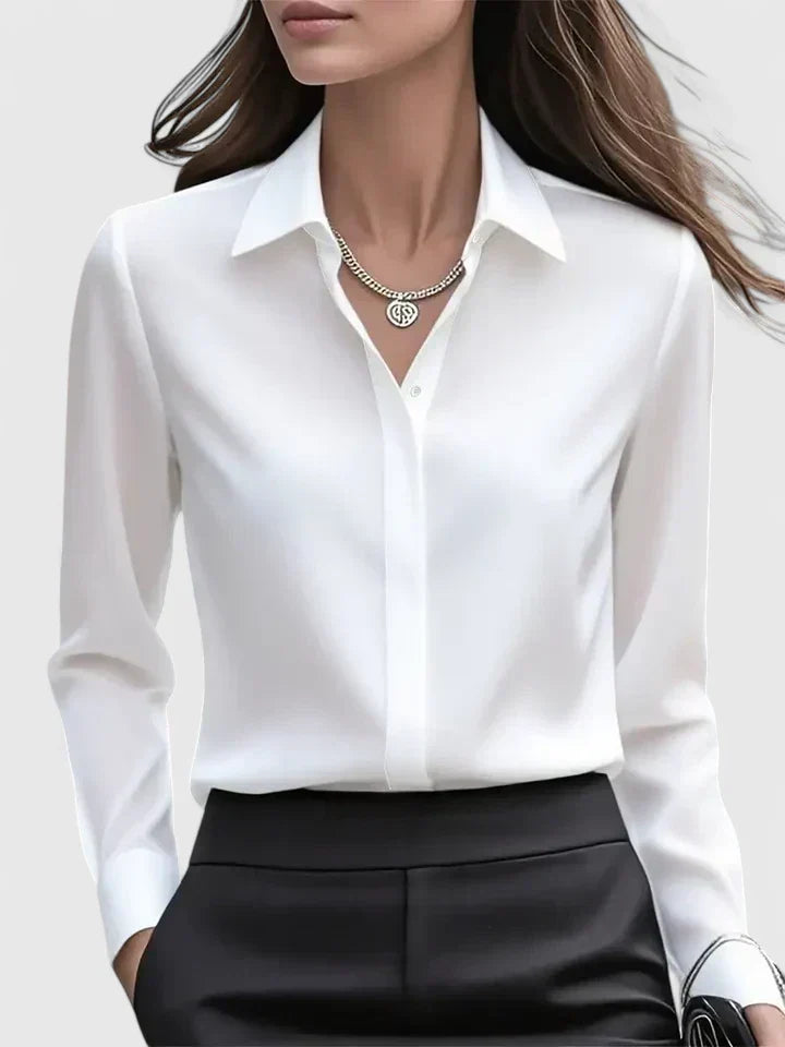 Front view of the white satin blouse with a pointed collar and hidden placket, worn with black trousers.