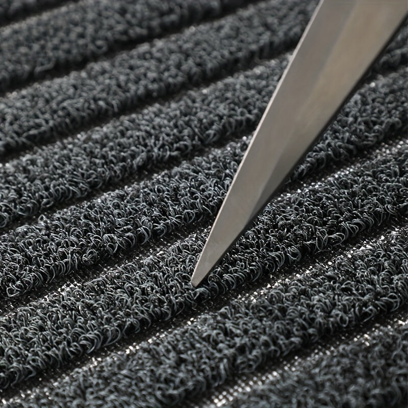Grey striped doormat detail showing dense curly loops in rows.