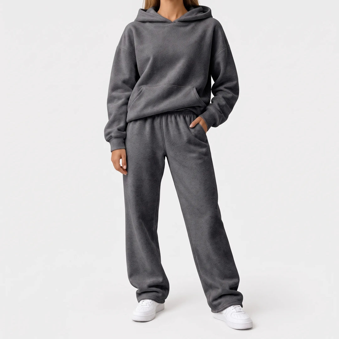 Full-length view of the charcoal gray hoodie and wide-leg sweatpants on a model with white sneakers 8