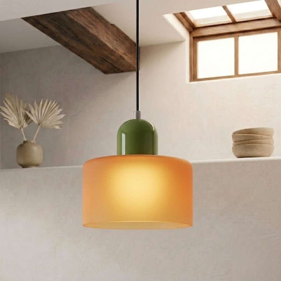 Lit frosted orange drum shade glowing softly, paired with a green rounded cap and black cord. 14