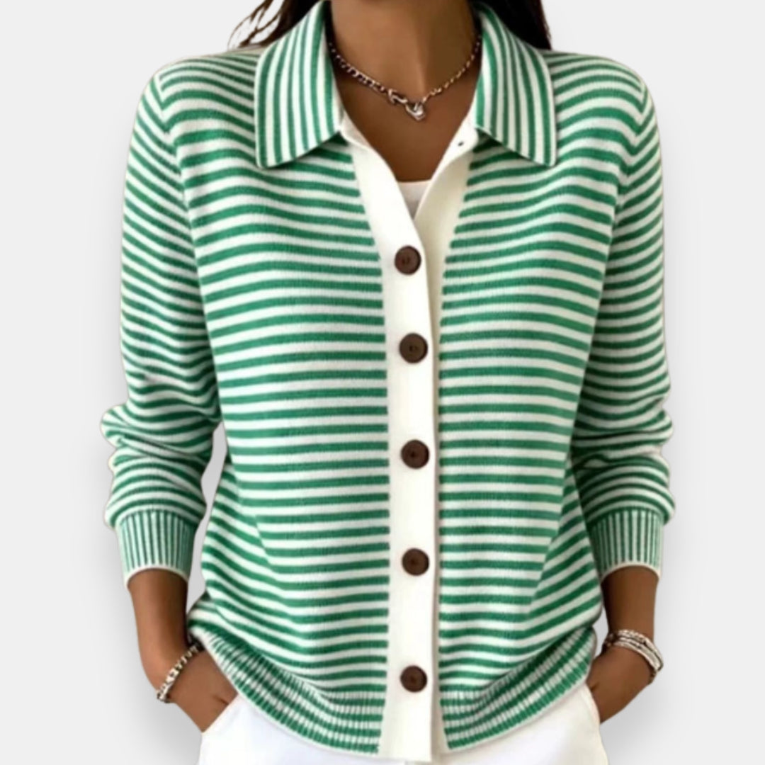 Woman wearing the collared cardigan in green and white stripes with brown buttons, white placket, ribbed cuffs, hands in pockets. 2