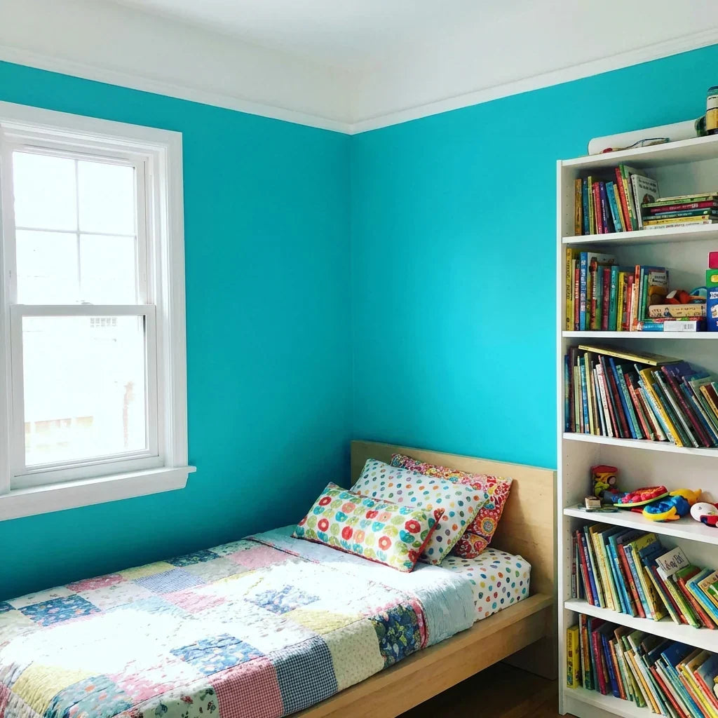 Child's bedroom with bright turquoise walls, white window frame and ceiling trim, a patchwork quilt on a bed, and a full bookshelf. 9