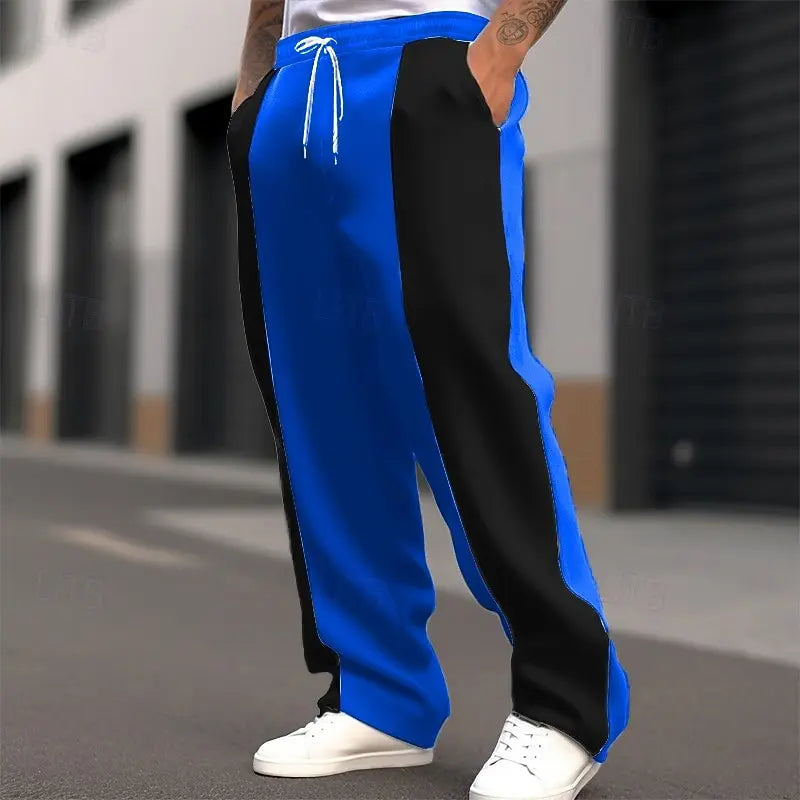 Cropped street shot of bright blue and black color-block sweatpants with drawstring waist and white sneakers 8