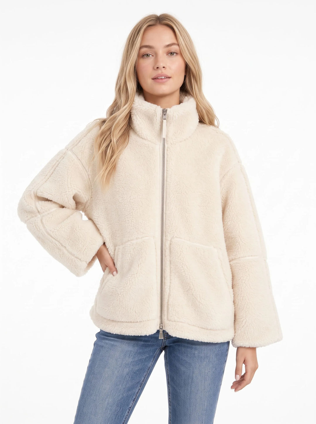 Model in a cream fleece zip coat with one hand on her hip, front view with blue jeans 8