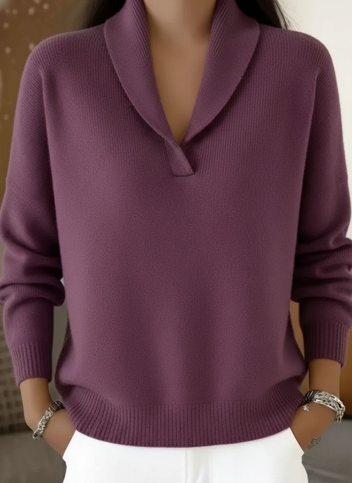 Model wearing the knit sweater in muted purple, showing the shawl collar and ribbed hem, with white pants and bracelets. 5