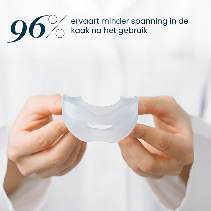 Two hands hold the clear silicone recovery mouthpiece in front of a white coat.