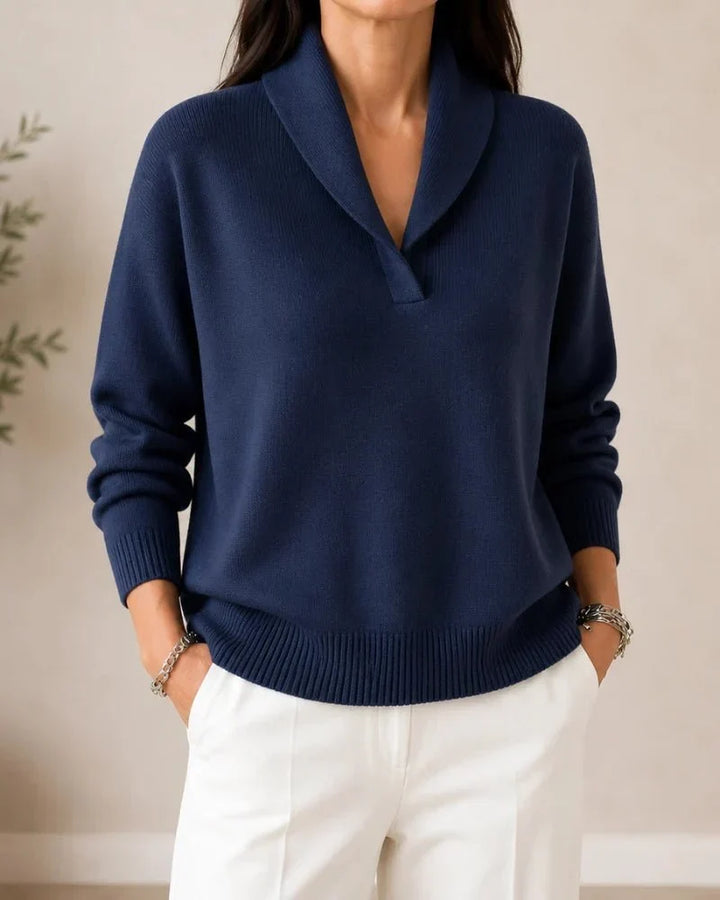 Front view of the sweater in navy blue worn by a model with white trousers. 7