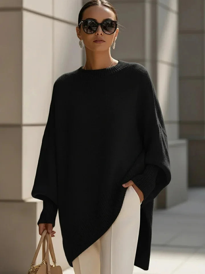 Woman in black loose knit sweater, sunglasses, white pants and a beige handbag near stone columns 8