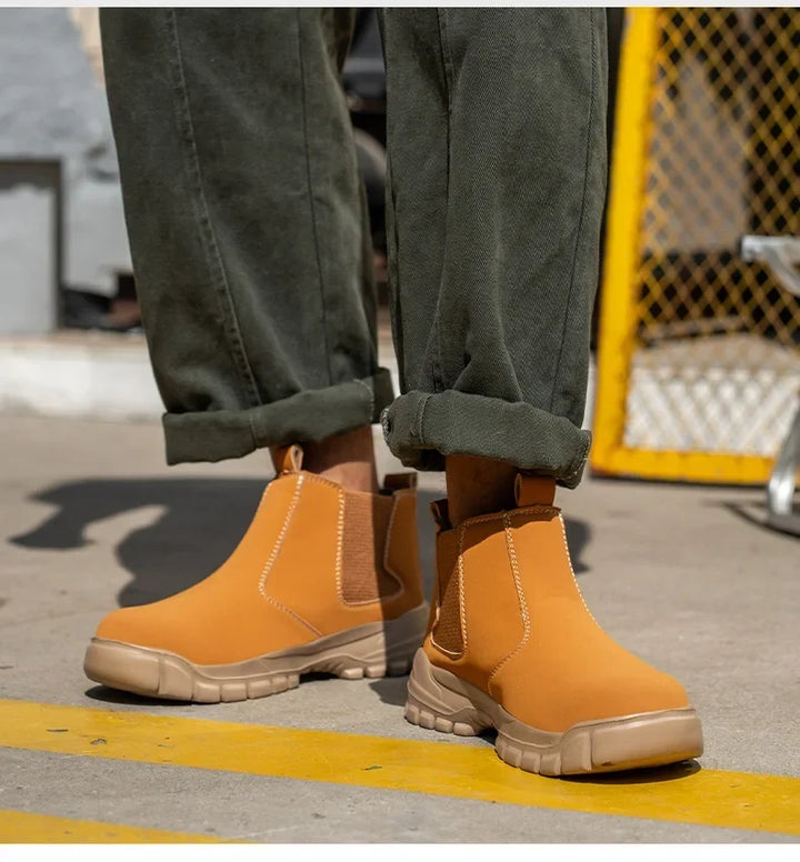 Tan boots worn with rolled olive pants, shown from the front beside a yellow mesh fence 8