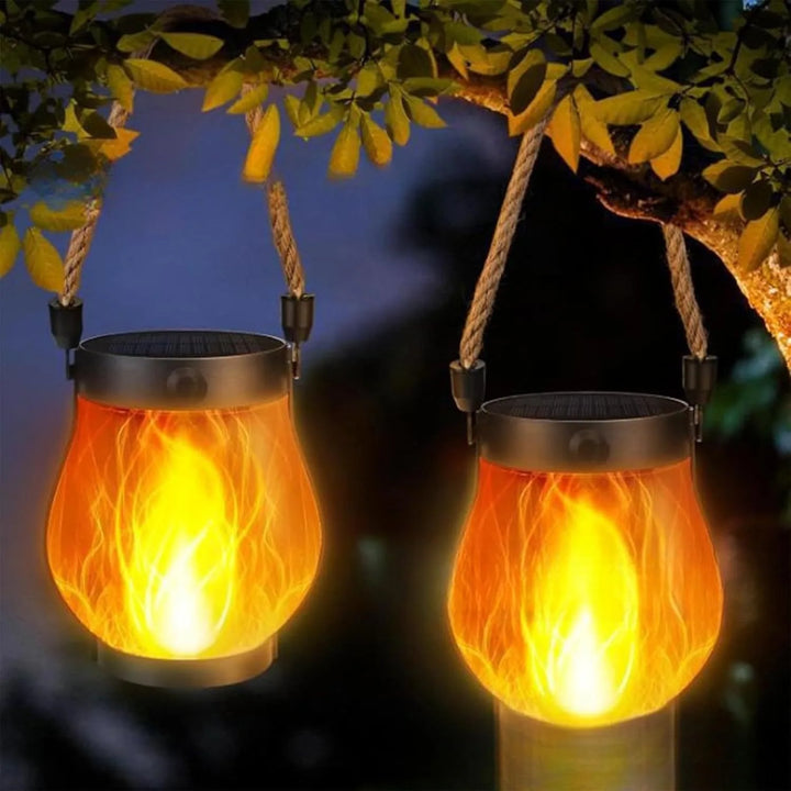 Two glowing lanterns hanging by their rope handles from a tree branch at dusk 8
