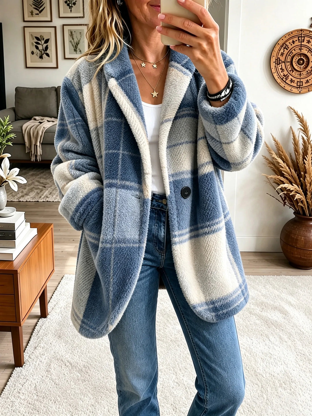 Woman wearing the plush plaid coat in a blue and cream colorway, open over a white top and jeans.