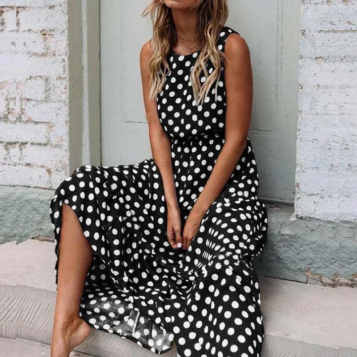 Woman seated on steps wearing the black polka dot version, hands resting in her lap 4