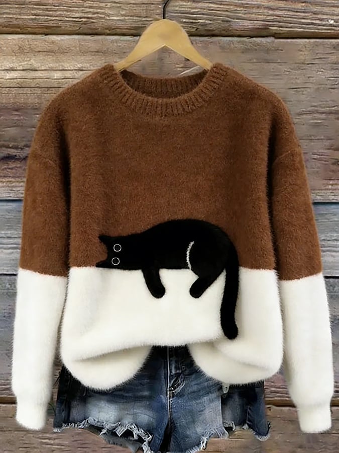 Brown and white fuzzy colorblock sweater with a black cat lounging across the middle, hanging above frayed denim shorts. 10
