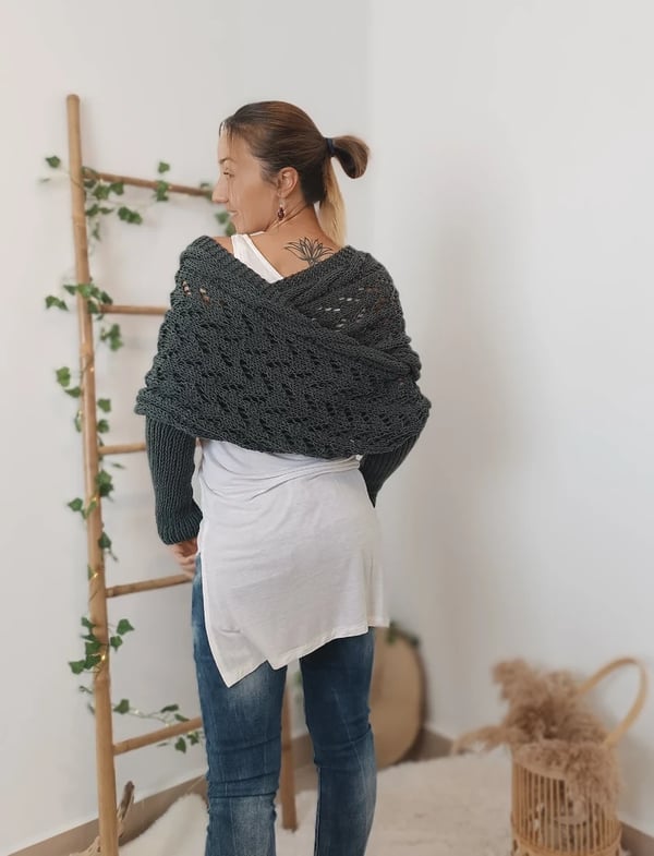 Back view of the dark gray wrap crossing over the shoulders and upper back, worn with a white top and jeans. 6