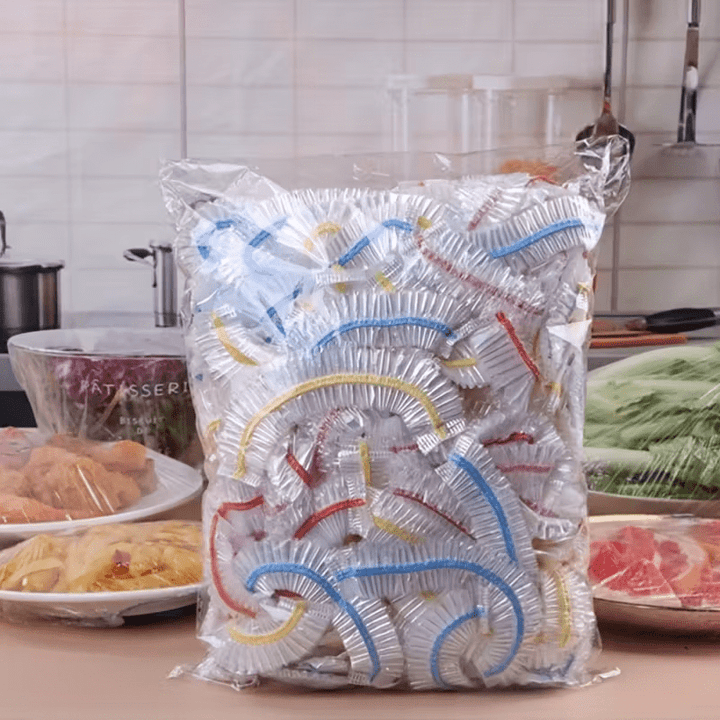 Large clear bag packed with elastic food covers with blue, red and yellow bands