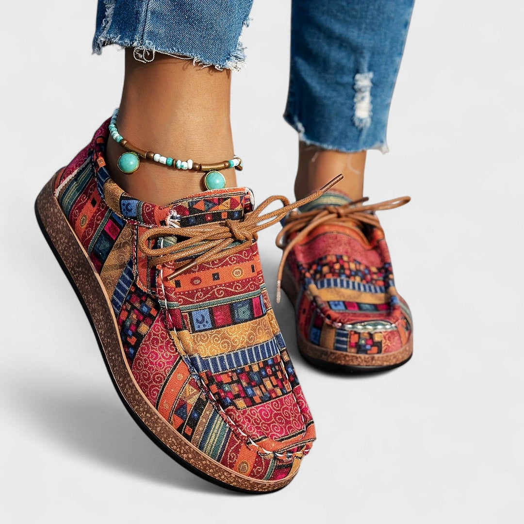 Front view of red and orange patterned lace-up sneakers with tan laces and cork-style soles.