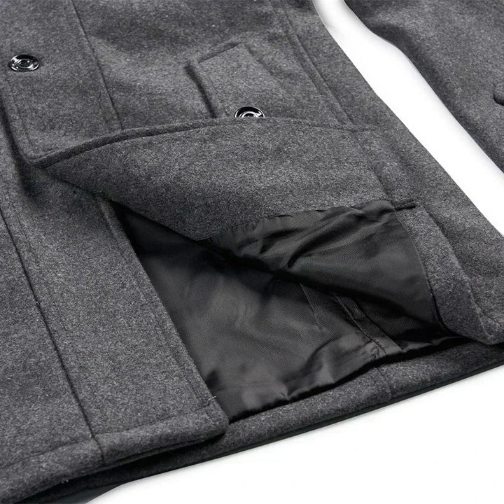 Close-up of a gray coat pocket flap lifted to show the black lining beneath 9