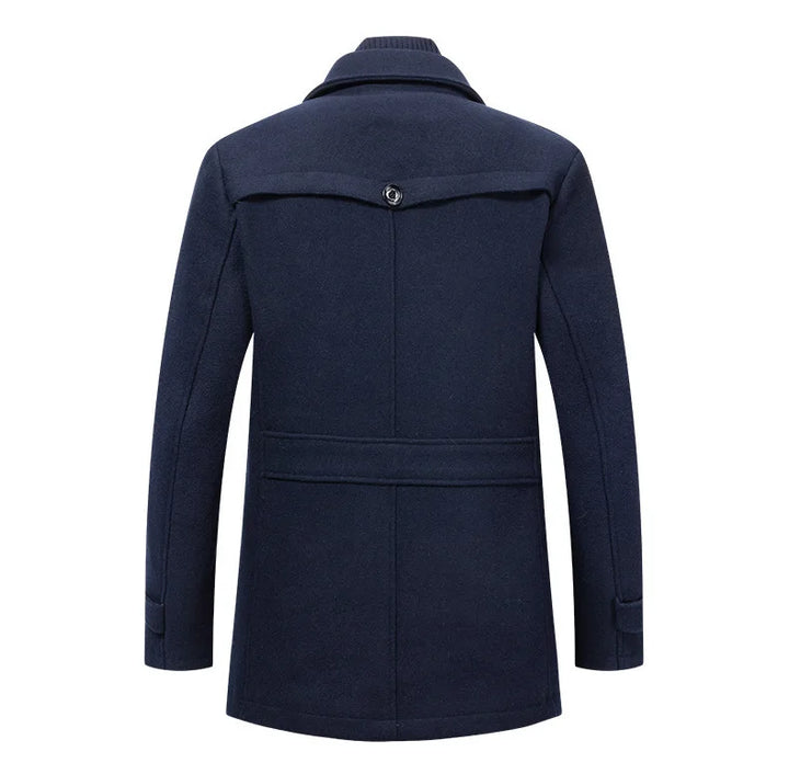 Back view of the navy overcoat, showing the buttoned back yoke, waist strap and cuff tabs 9