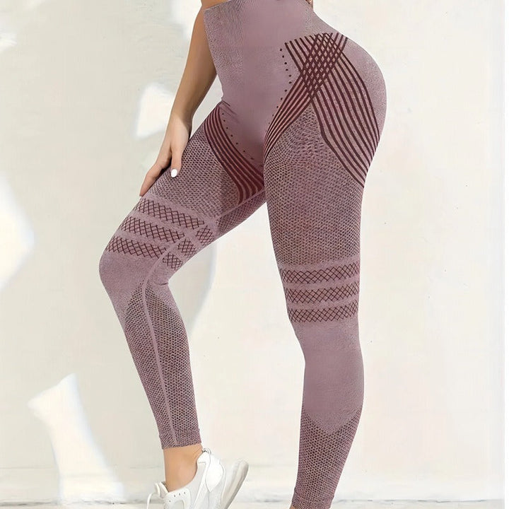 Side view of dusty mauve seamless leggings with dark red striped hip panels and mesh thigh bands, worn with white sneakers. 22
