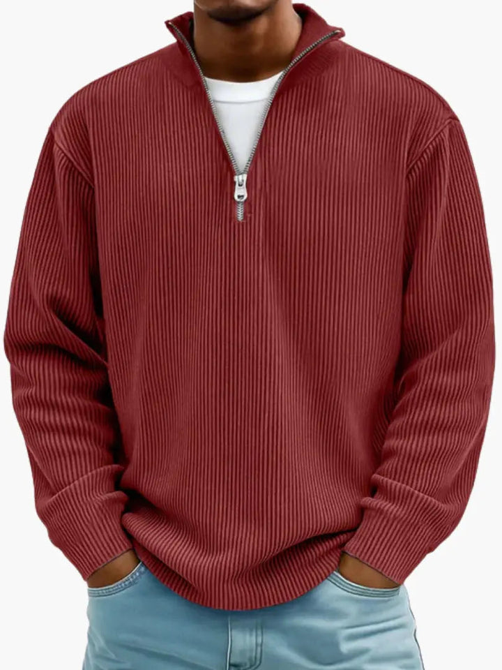 Man wearing the ribbed quarter-zip sweater in burgundy red over a white tee, hands in jeans pockets.