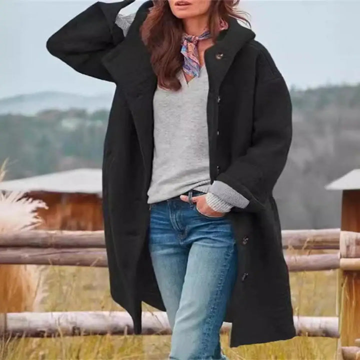 Black hooded coat worn open with scarf and jeans, standing in front of a wooden fence 9