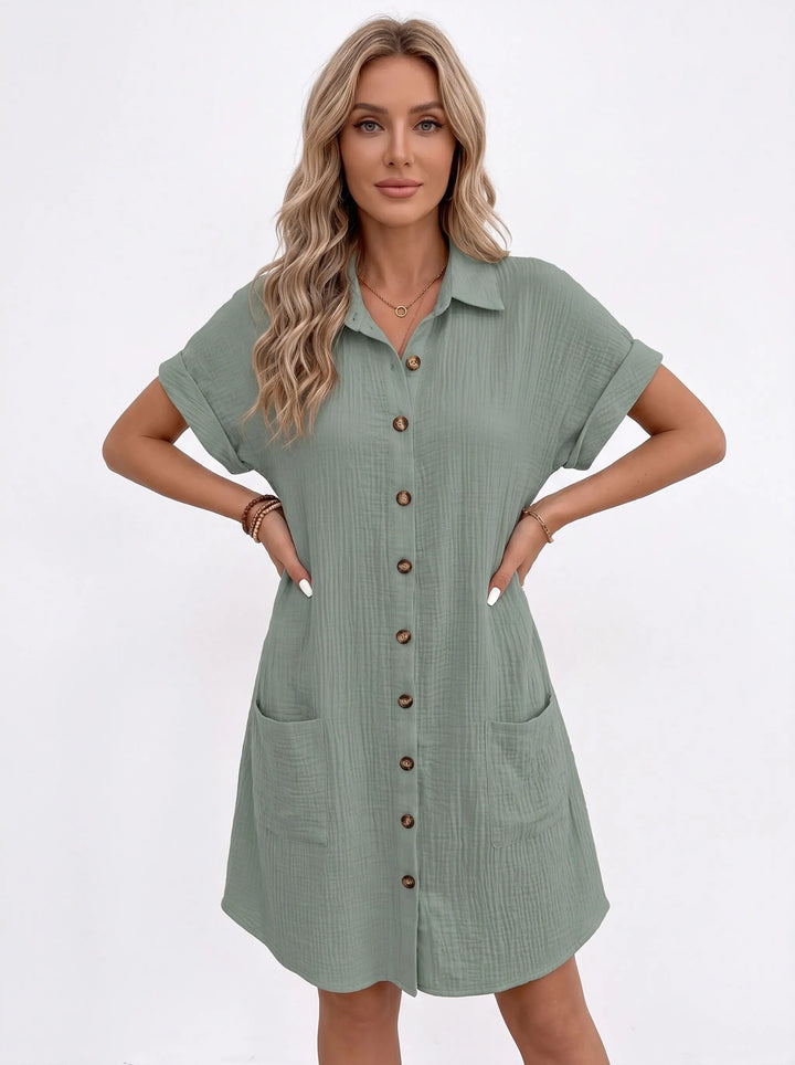 Sage green button-front shirt dress with two patch pockets, model standing with both hands on hips 9