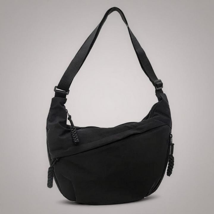 Red crescent shoulder bag with an adjustable strap and braided zipper pulls, another view.