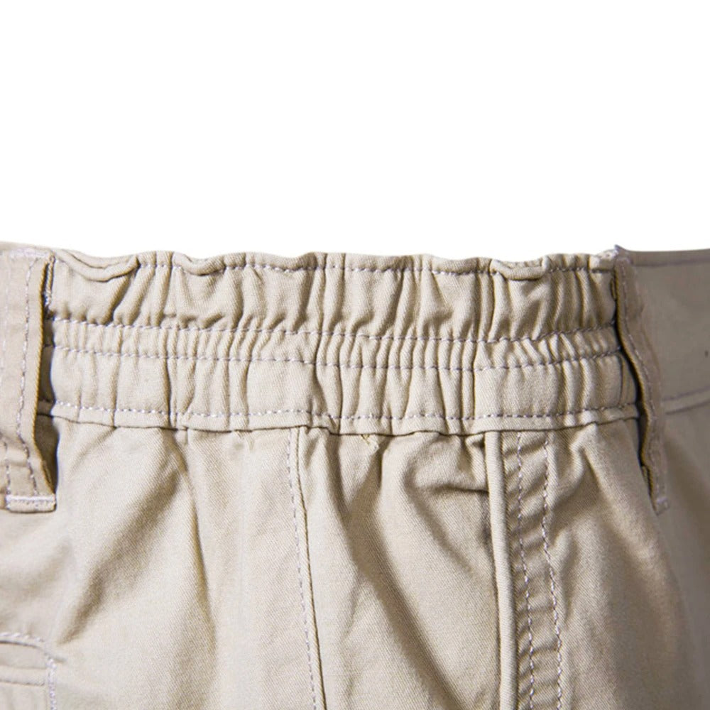 Close-up of the gathered elastic waistband and belt loops on beige shorts 4