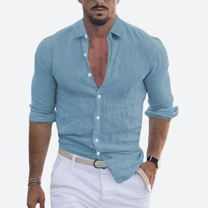 Men's linen shirt in dusty blue with an open collar and rolled sleeves.