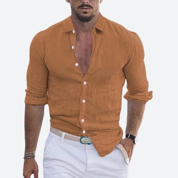 Men's linen shirt in warm caramel brown with an open collar and rolled sleeves.