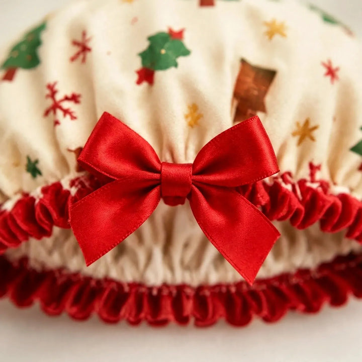 Close-up of the cream shower cap with festive print, red satin bow and ruffled red trim 3