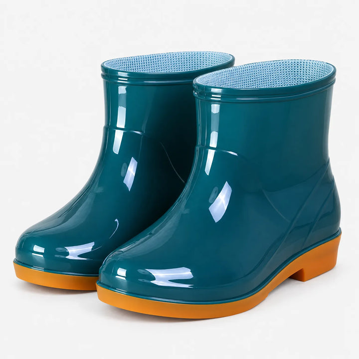 Pair of glossy teal ankle rain boots with orange soles and light blue mesh lining, shown at an angle on white. 2