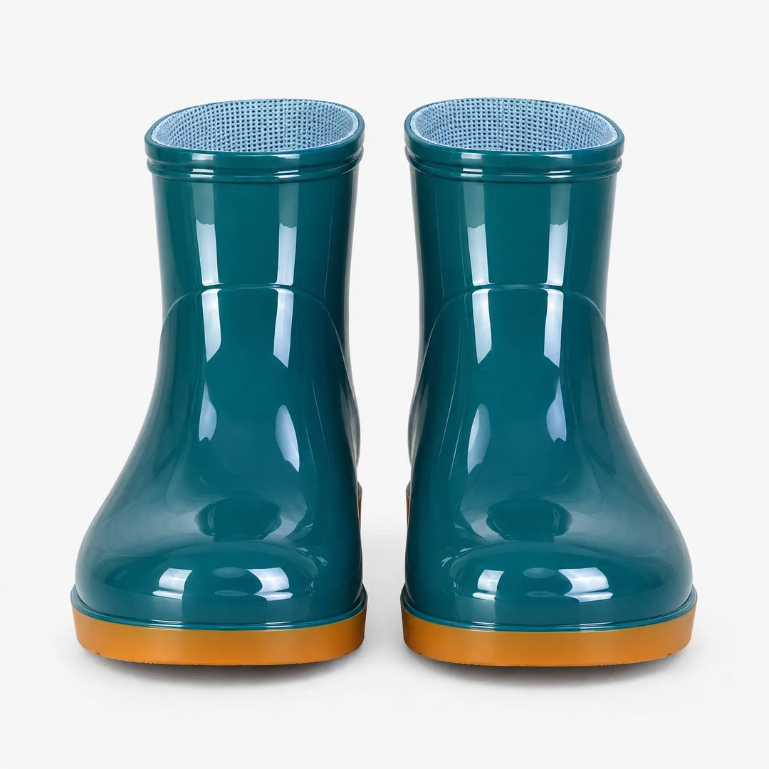 Front view of a pair of glossy teal ankle boots with orange soles and light blue mesh lining inside. 7