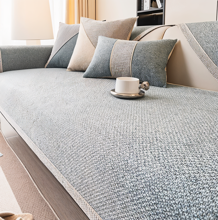 Slate gray version of the cover on a sofa, with coordinating pillows and a white cup on the seat. 6