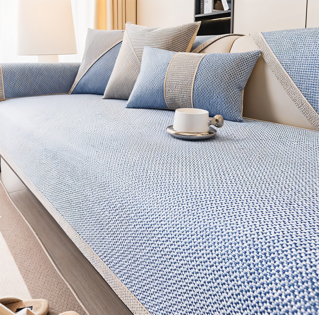Light blue version of the cover on a sofa, with blue and gray pillows and a white cup on the seat. 7
