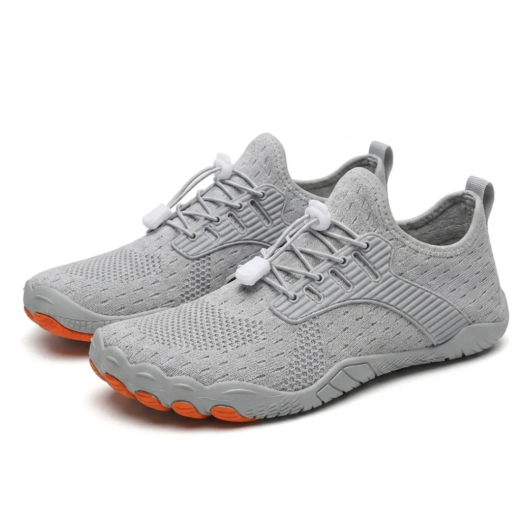 Pair of gray knit barefoot sneakers shown at an angle, with orange toe tips and white lace toggles.