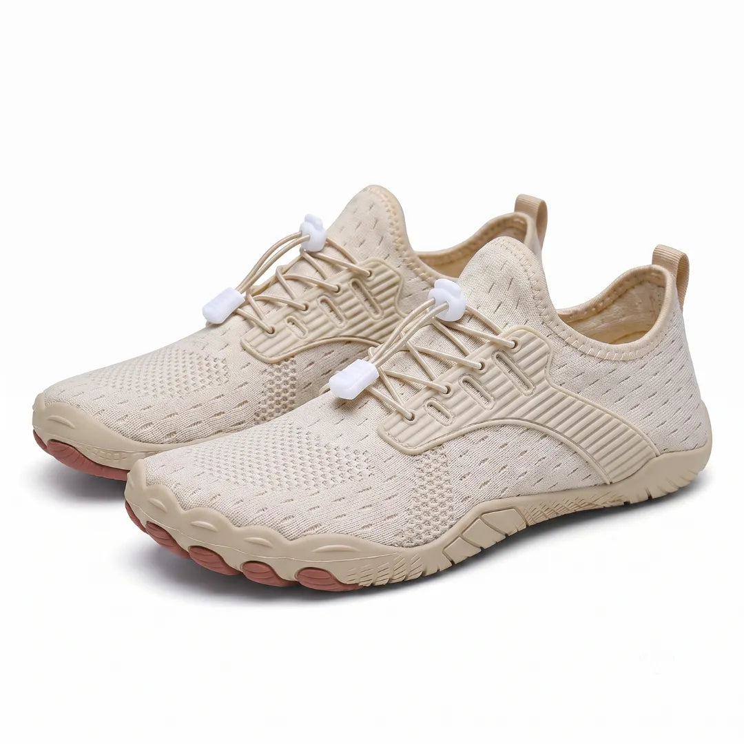 Pair of beige knit barefoot sneakers with elastic toggle laces and brown toe-shaped sole pods, shown at an angle. 22