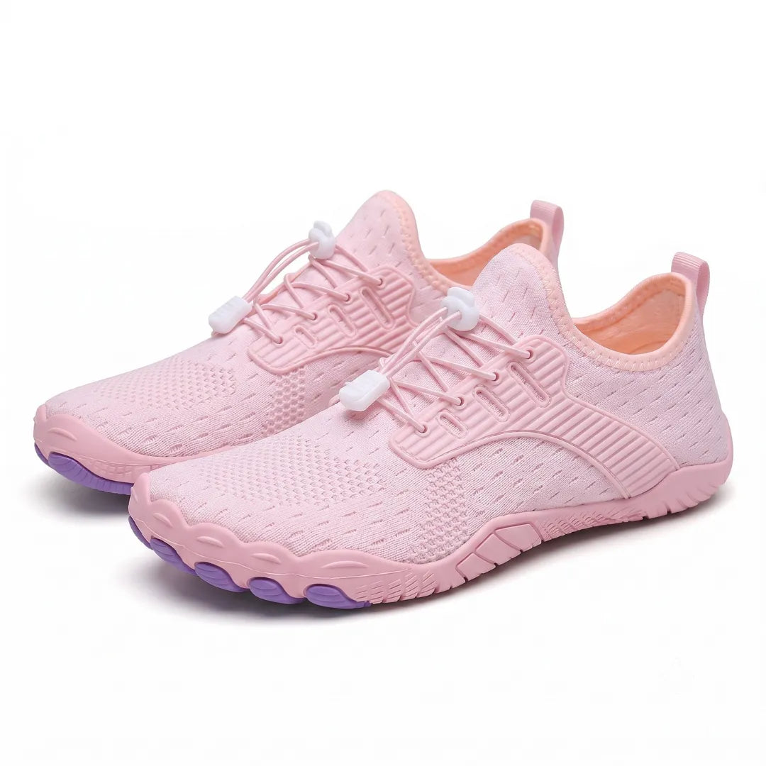 Pair of pink knit barefoot sneakers with white lace toggles, orange lining and purple toe pods, shown at an angle. 29