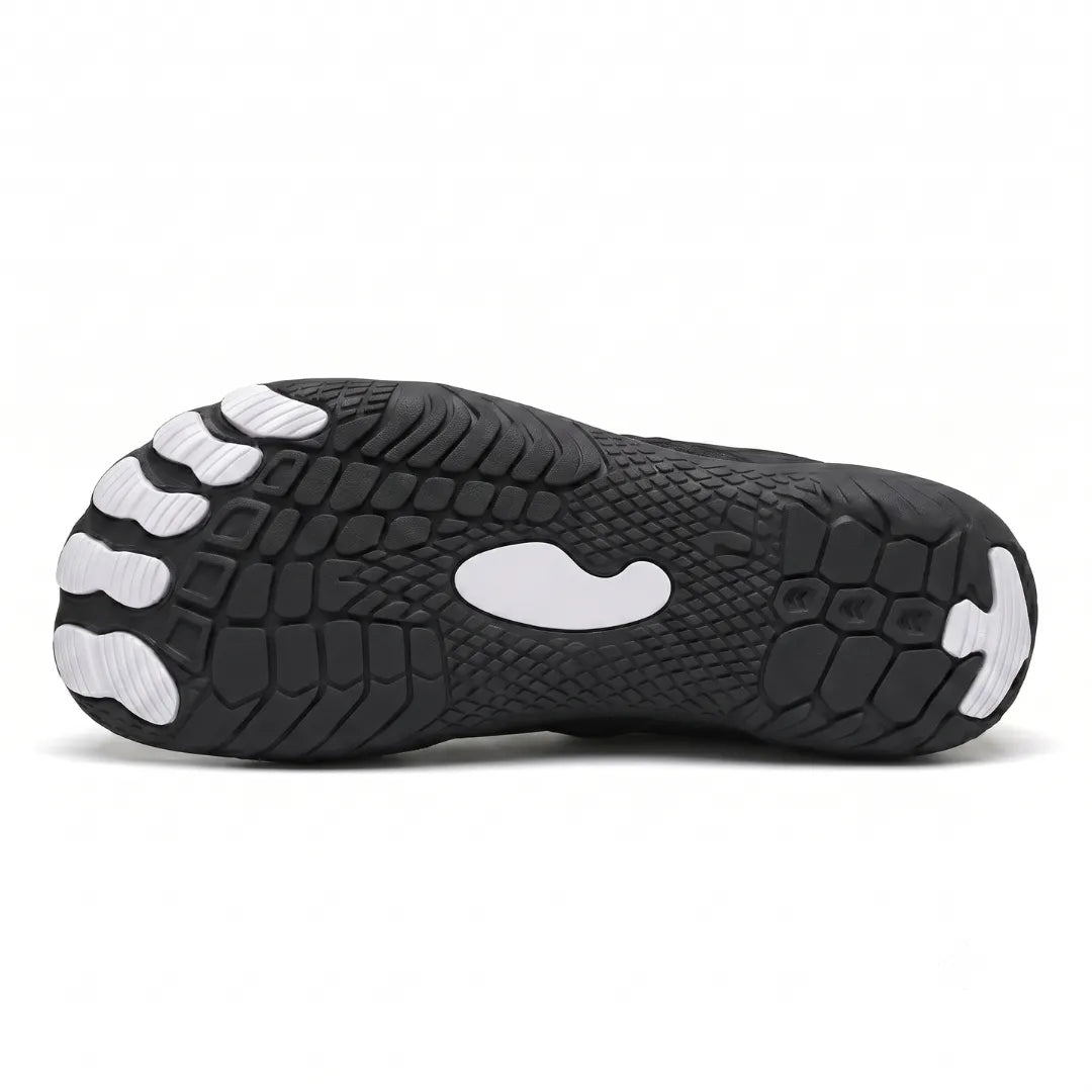 Underside of a black sneaker showing the textured tread with white toe pods and a white center patch. 38