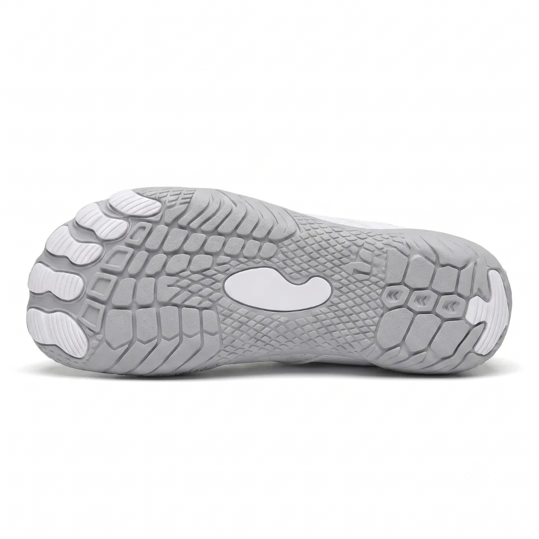 Underside of a white sneaker showing the gray textured outsole with separate toe pads and a central white oval.
