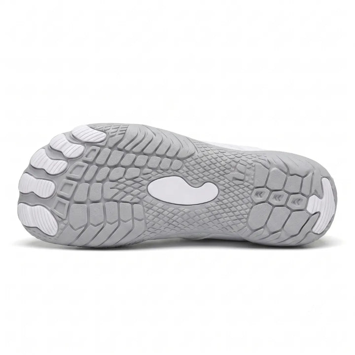 Underside of a white sneaker showing the gray textured outsole with separate toe pads and a central white oval.