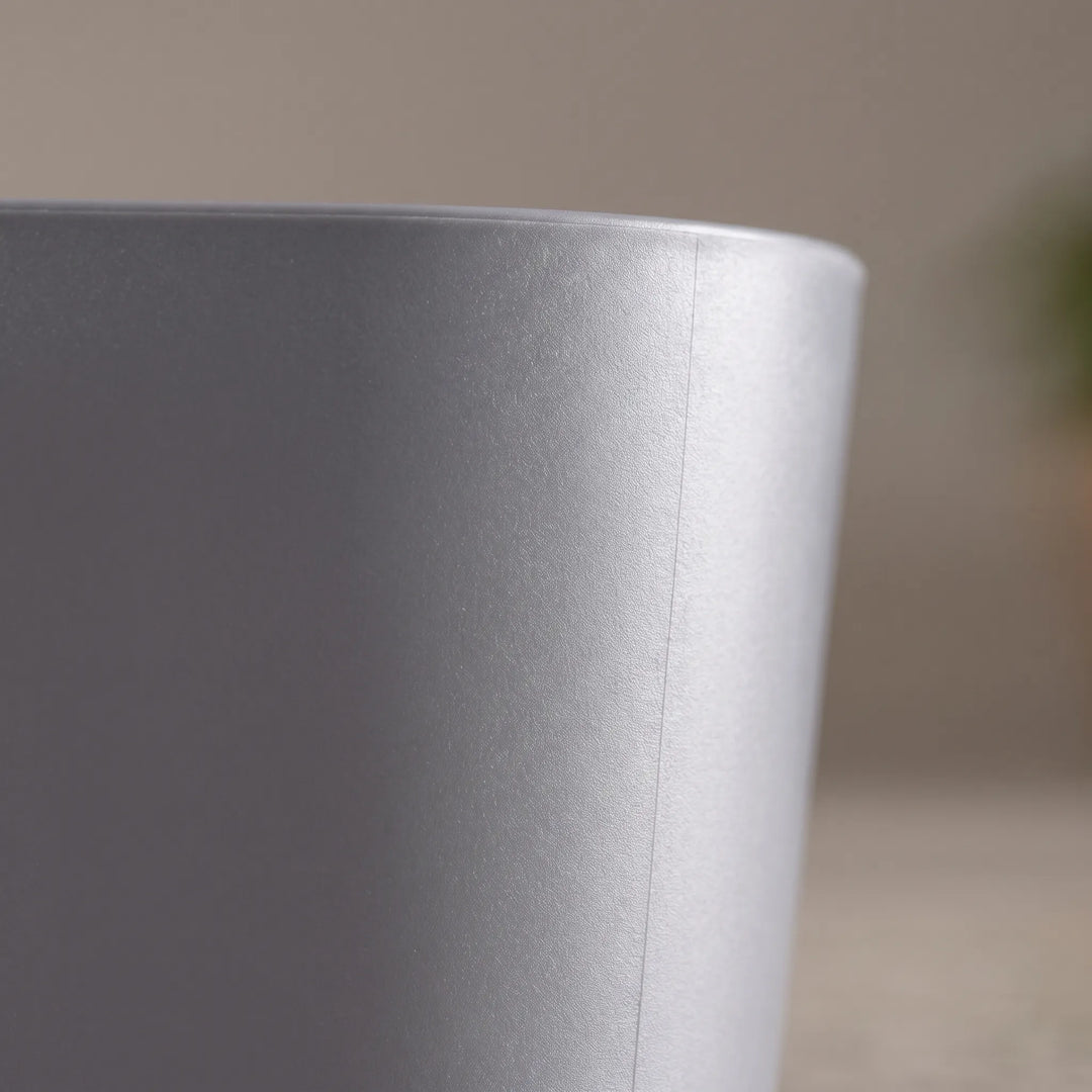 Close-up of the gray plastic basin's smooth, slightly textured outer wall and rounded rim against a softly blurred background. 3