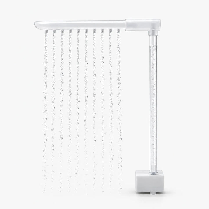 Side view of the rain bar with a clear upright tube and square white pump base, with ten streams of water falling. 4