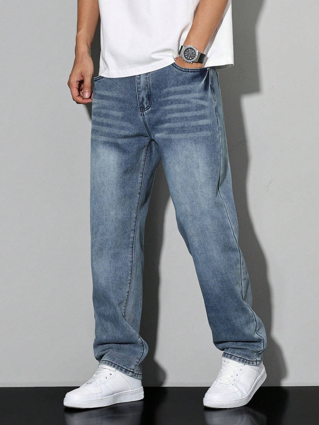 Men's baggy jeans in faded blue denim, another view with whiskering at the hips and a wide straight leg.