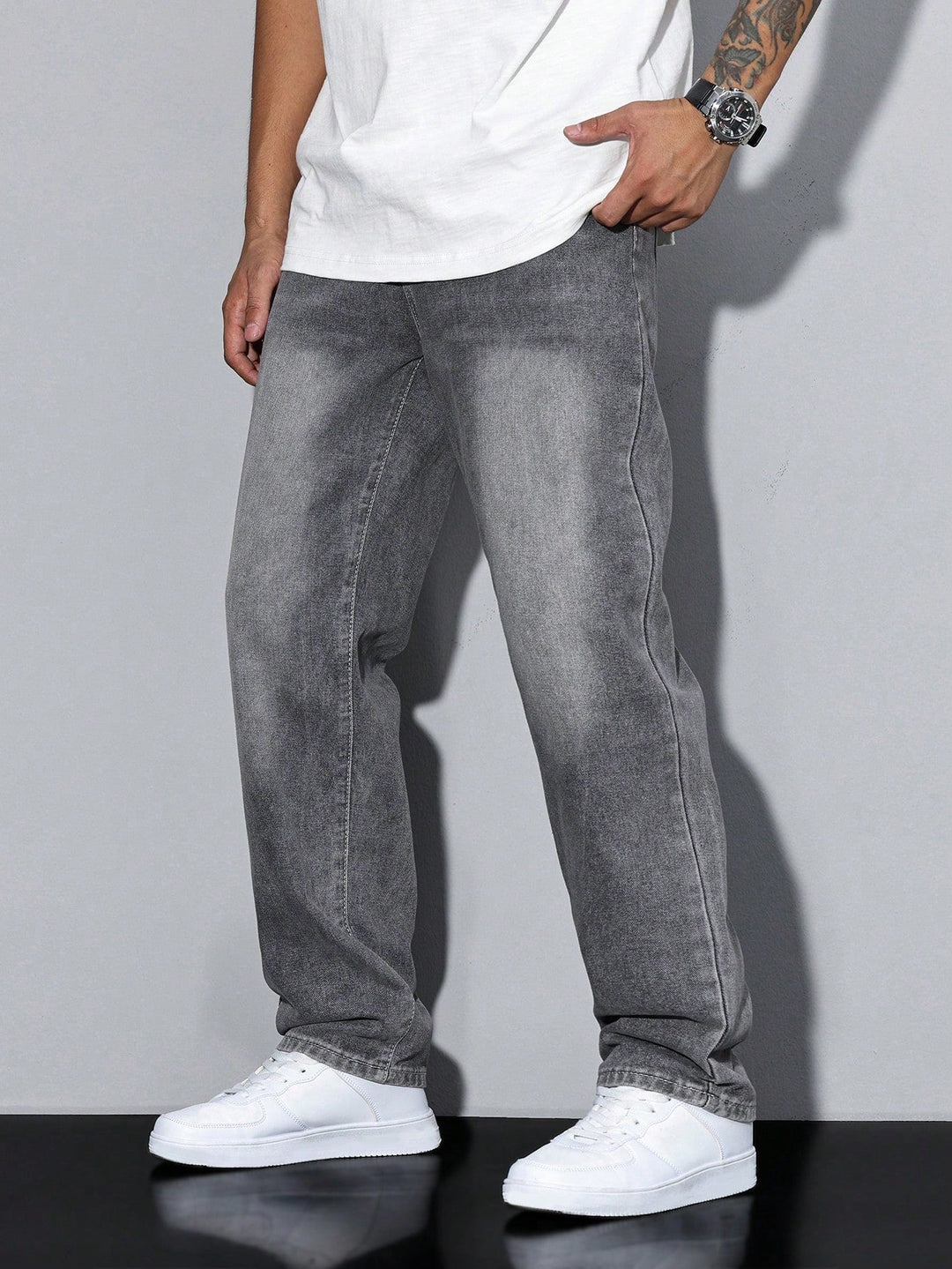 Men's baggy jeans in gray washed denim, side view on a model with a hand in the pocket.