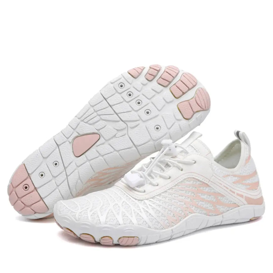 White mesh barefoot shoes with pink accents, one shoe tilted to show the pink-toed textured sole, the other upright with bungee laces.