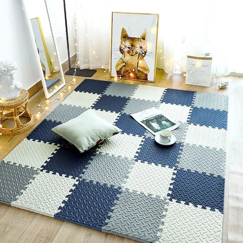 Navy, gray and cream foam puzzle tiles in a checkerboard layout on a wood floor.