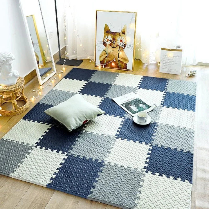 Navy, gray and cream foam puzzle tiles in a checkerboard layout on a wood floor.