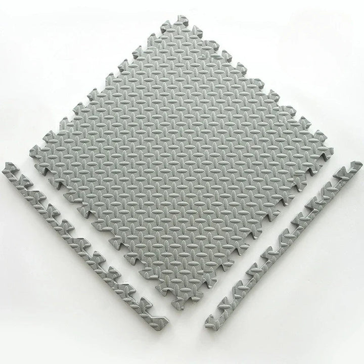 Single light gray foam puzzle tile with a textured leaf pattern and two detached border strips.
