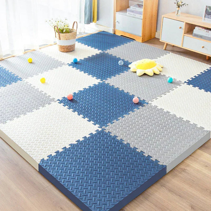 Thick navy, gray and cream foam tiles in a checkerboard on a wood floor.